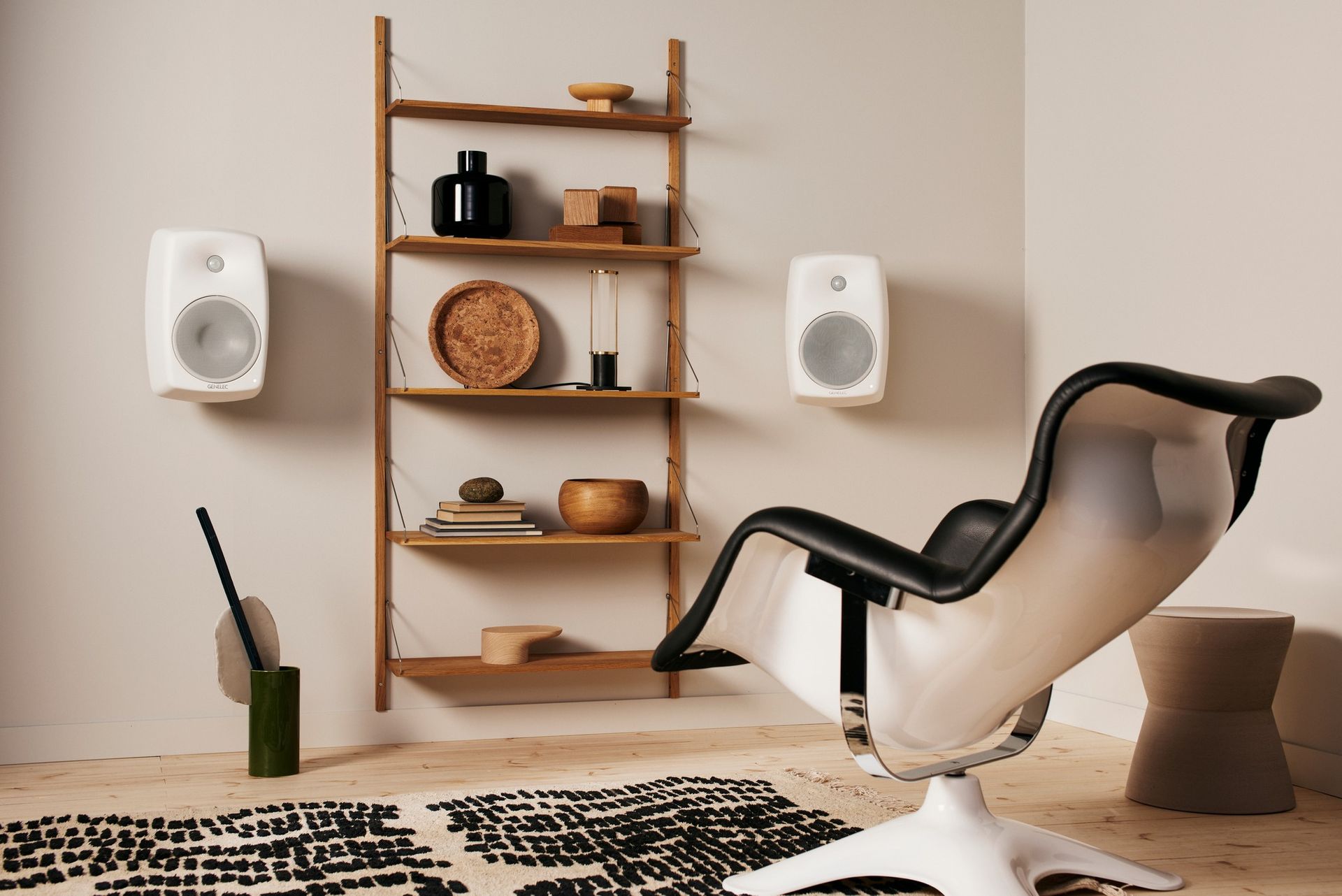 Modern living room with Genelec wall speakers and mid-century style shelving