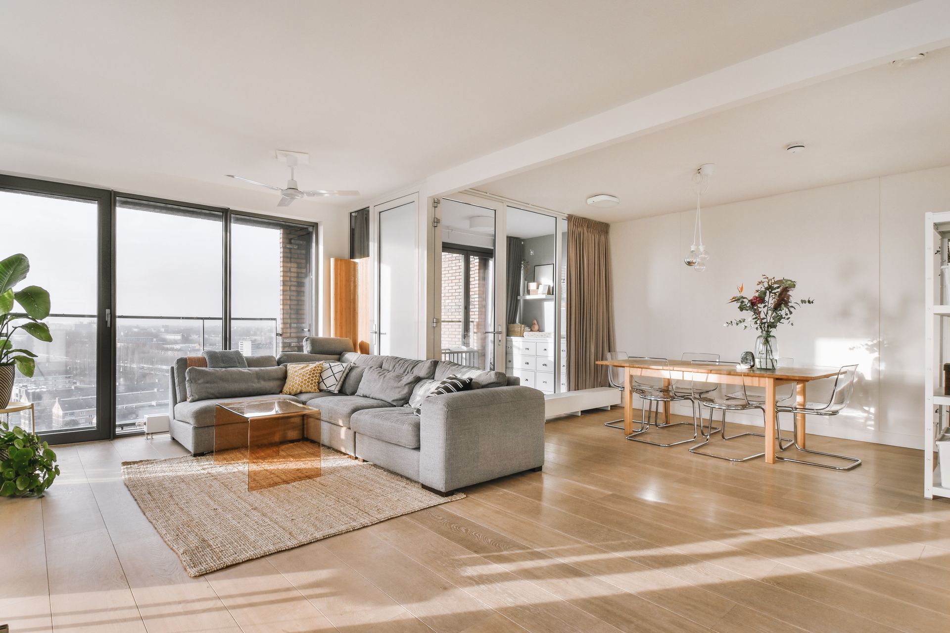 Modern open-concept living room with large windows, natural light, and connected smart home devices.
