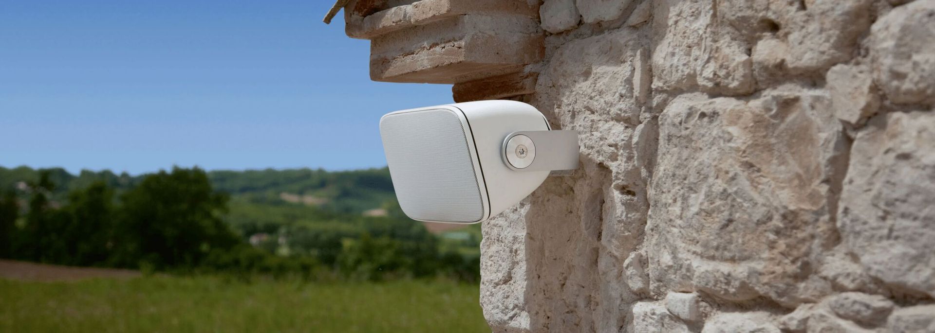 Outdoor smart speaker mounted on stone wall with scenic Bonney Lake view