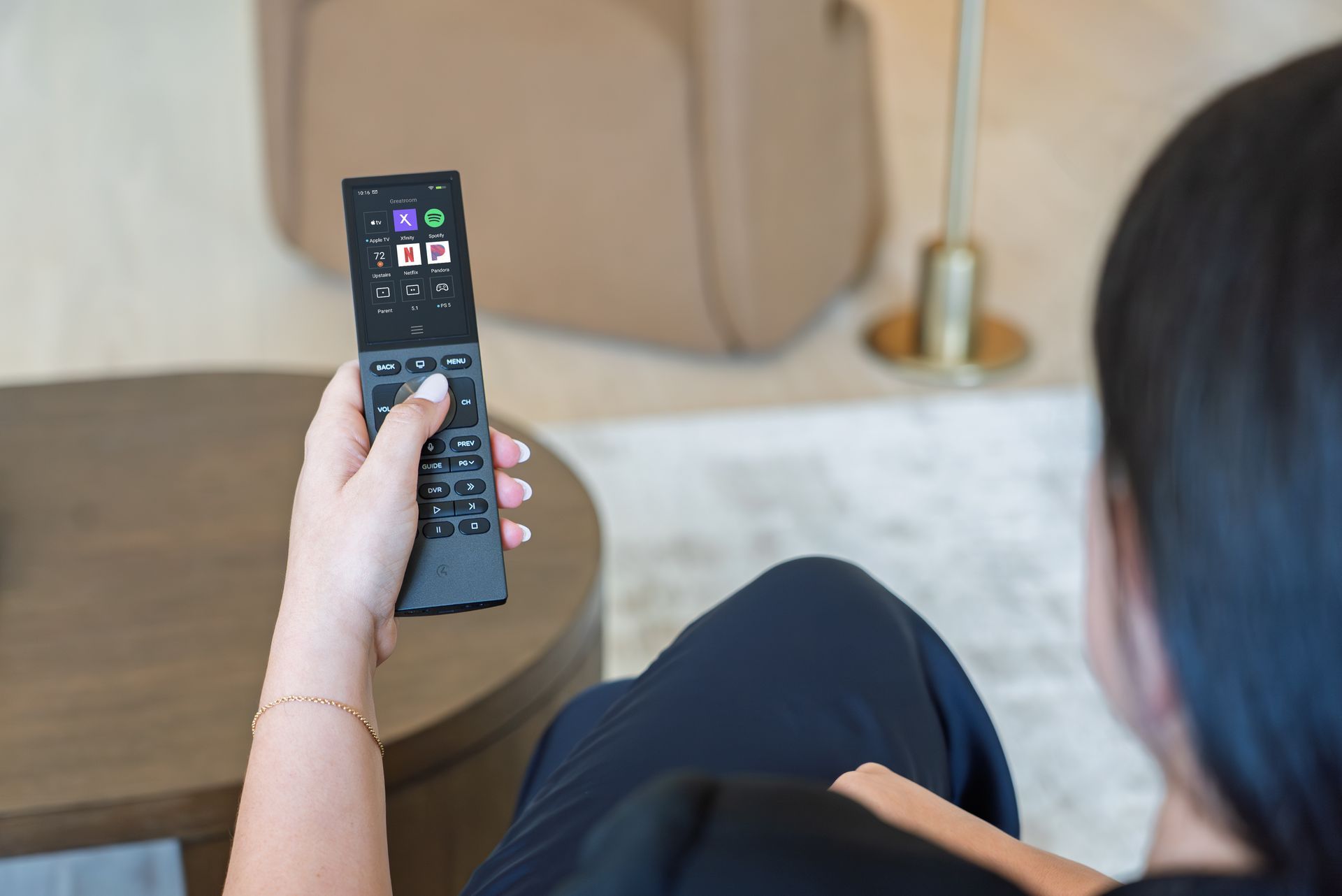 Person holding a smart remote control for a home theater system.