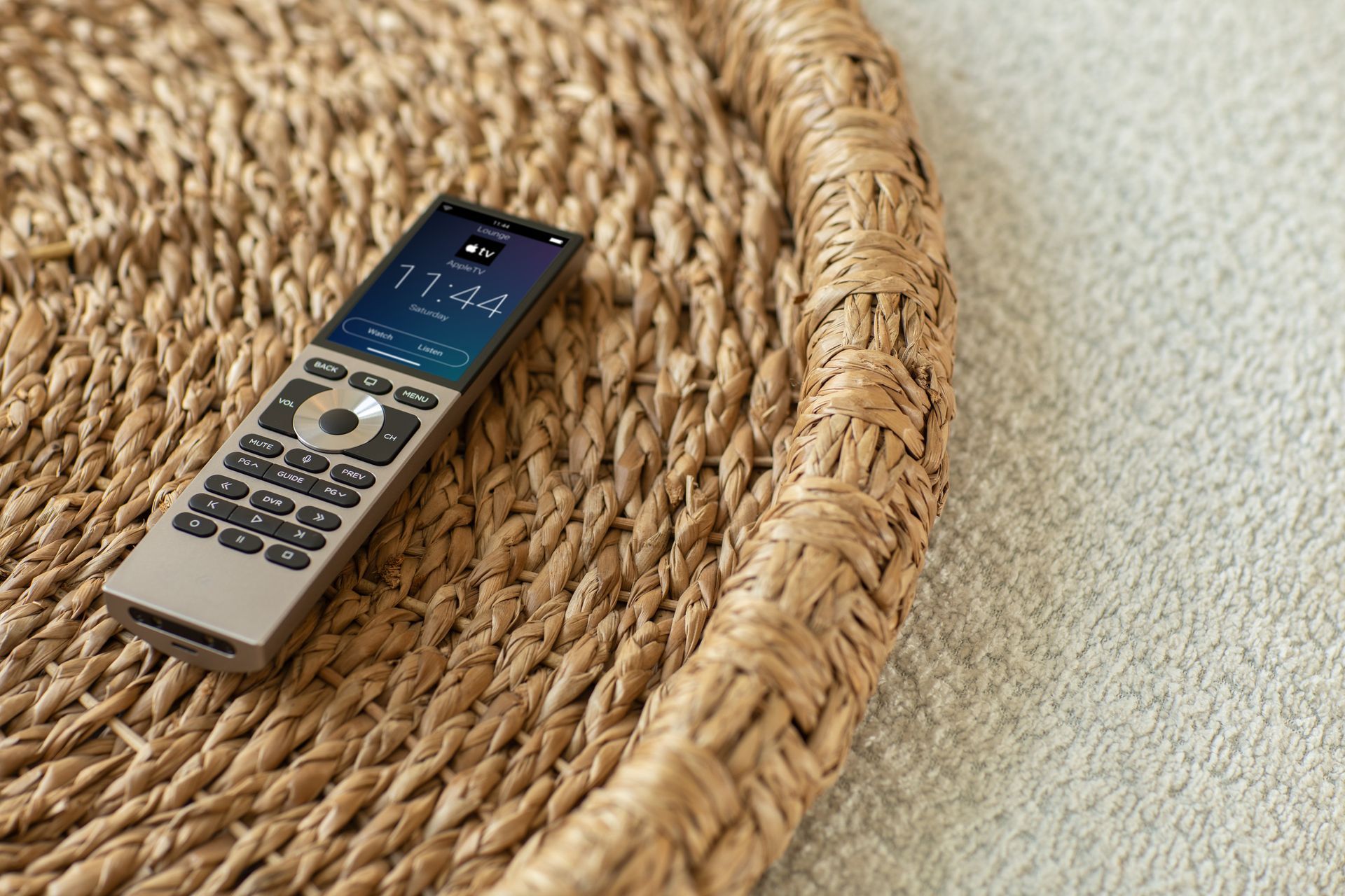 Control4 Halo remote resting on a woven tray, showcasing its elegant design and intuitive smart home interface — featured by Rivas Technology Group.