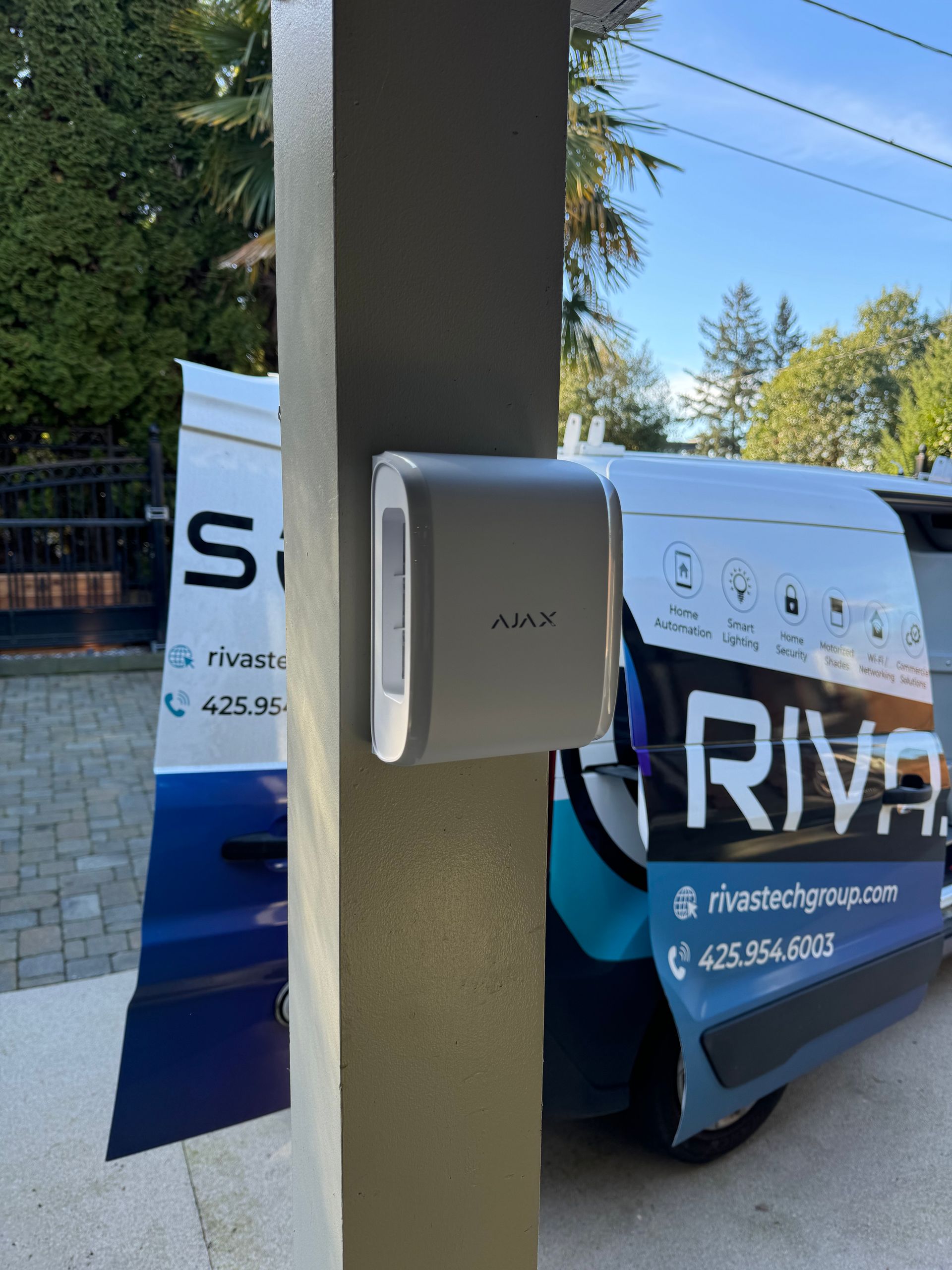 Ajax DualCurtain Outdoor perimeter motion detector mounted outside a South Sound residence by Rivas Technology Group