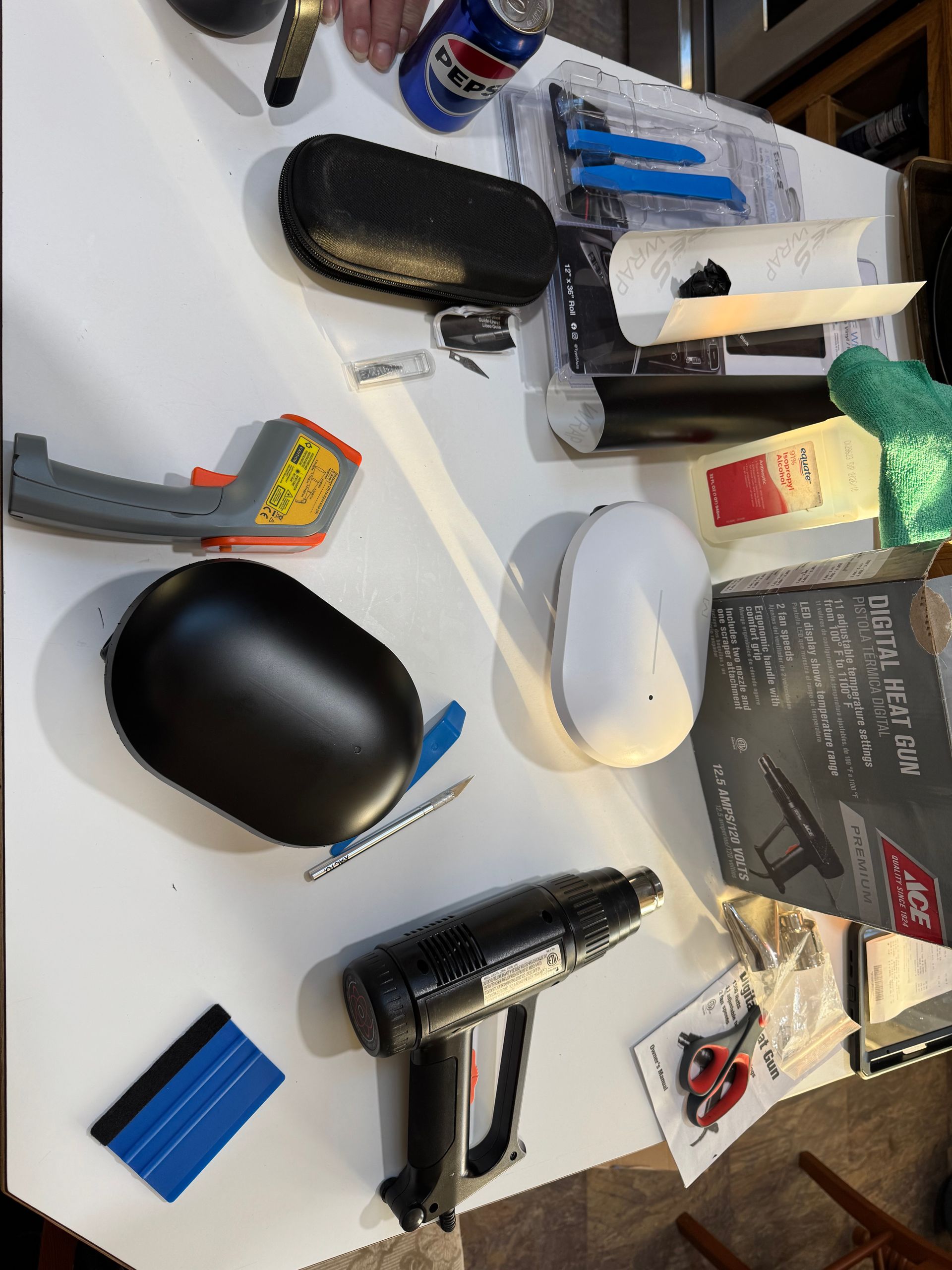 Workbench setup with tools, vinyl wrap, and heat gun used for AP6-PRO customization.