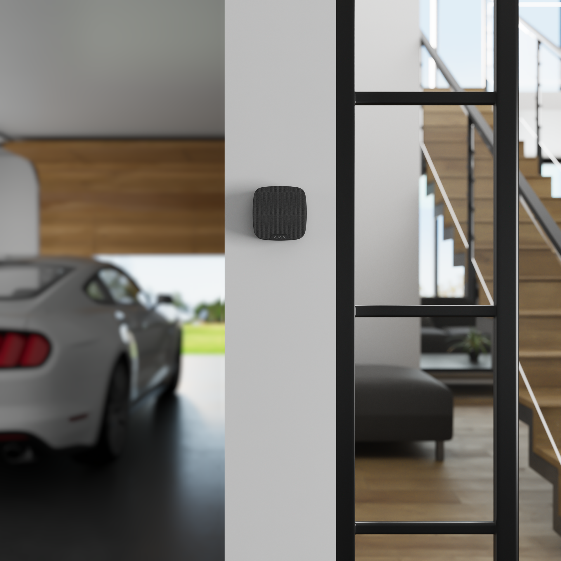 Ajax indoor siren mounted on a wall inside a modern home near a garage entrance.