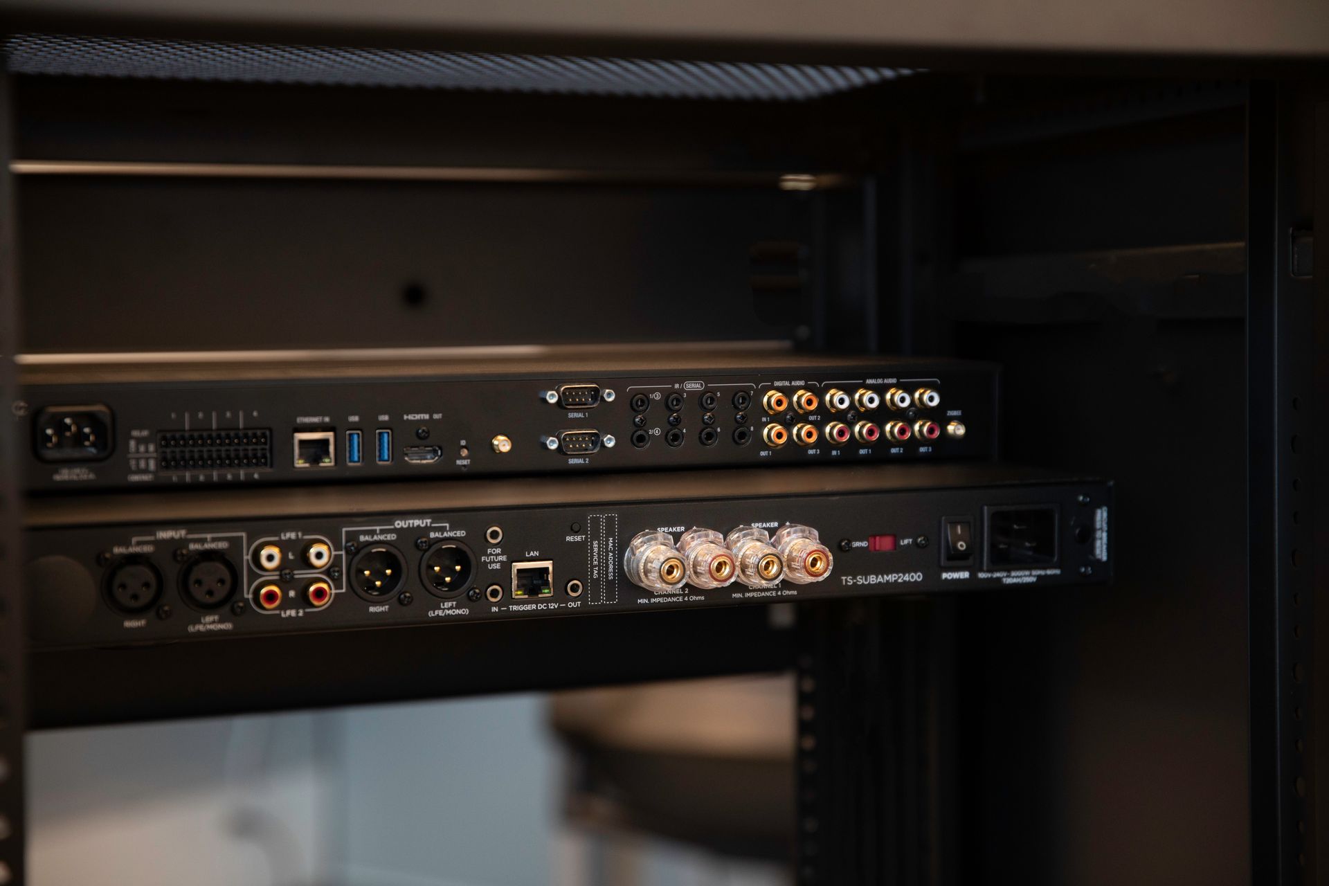 Close-up of a professional AV rack showing neatly installed Control4 home theater and audio equipmen
