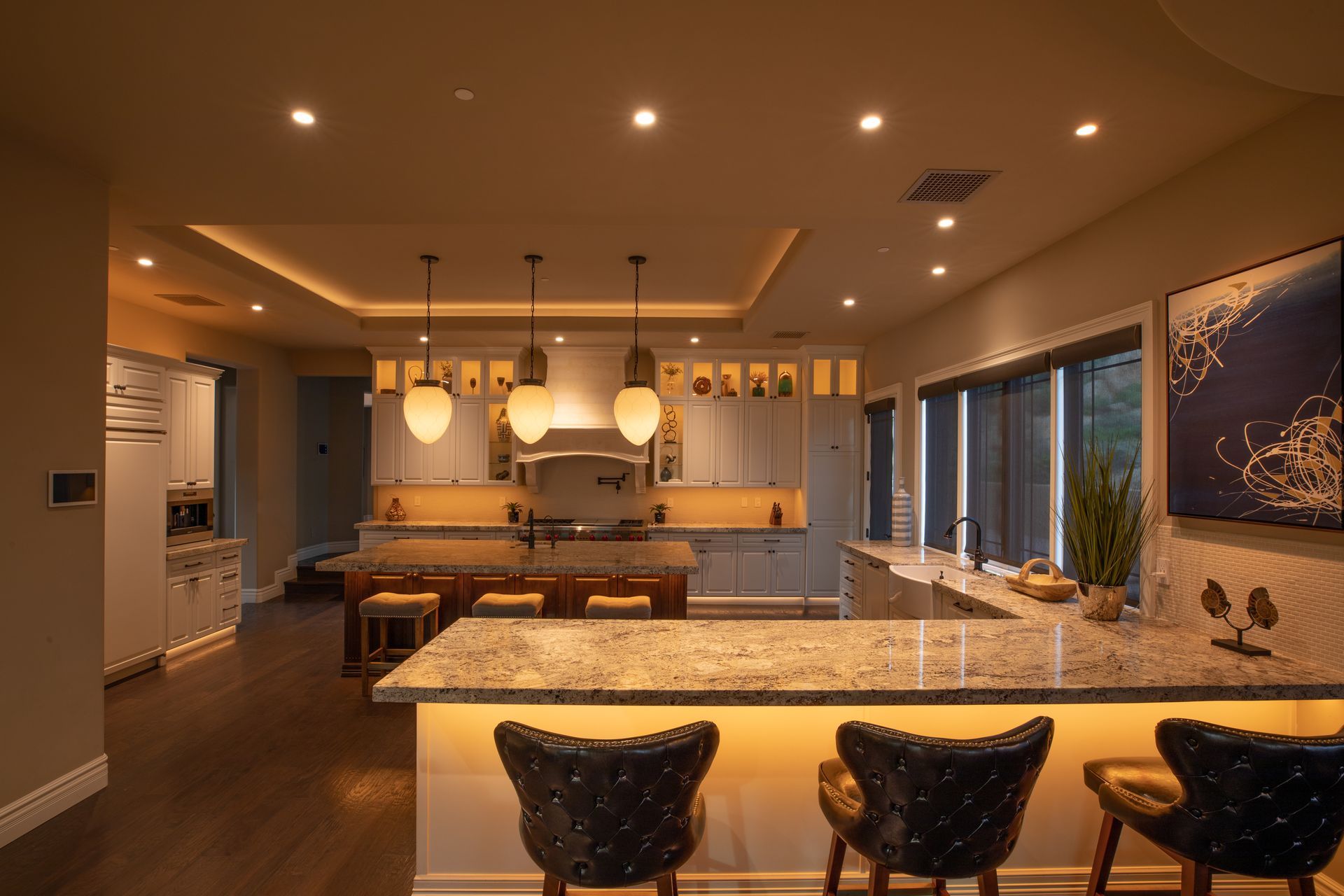 Warm architectural lighting and Control4 lighting control enhance this luxury kitchen’s ambiance and functionality.