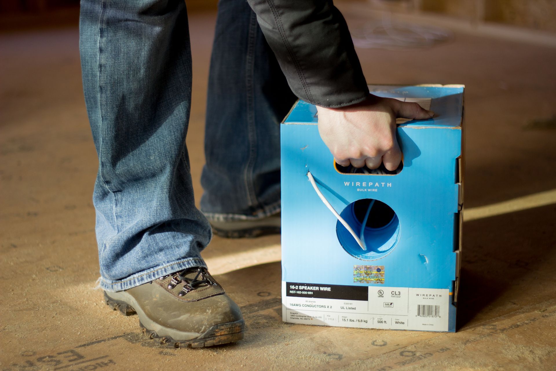 Technician pulling Wirepath bulk wire during structured cabling installation.