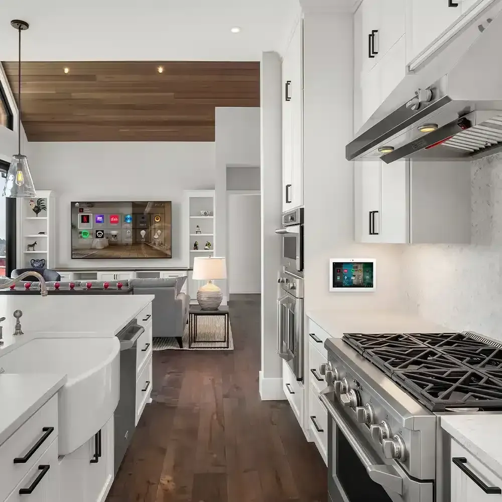 A kitchen with a stove and a television on the wall