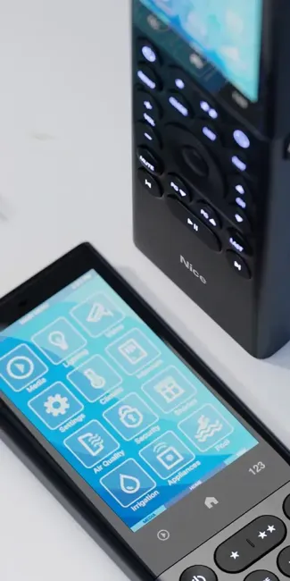 A cell phone is sitting next to a remote control on a table.