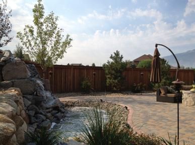 There is a waterfall in the middle of the backyard.