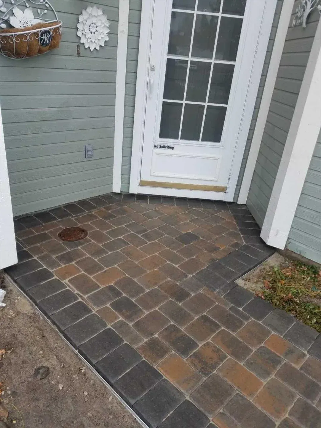 A brick walkway leading to the front door of a house.