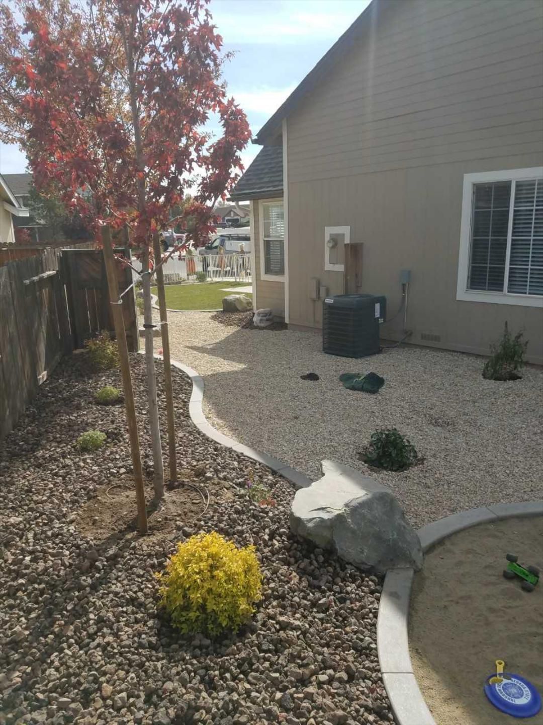 The backyard of a house with gravel and trees