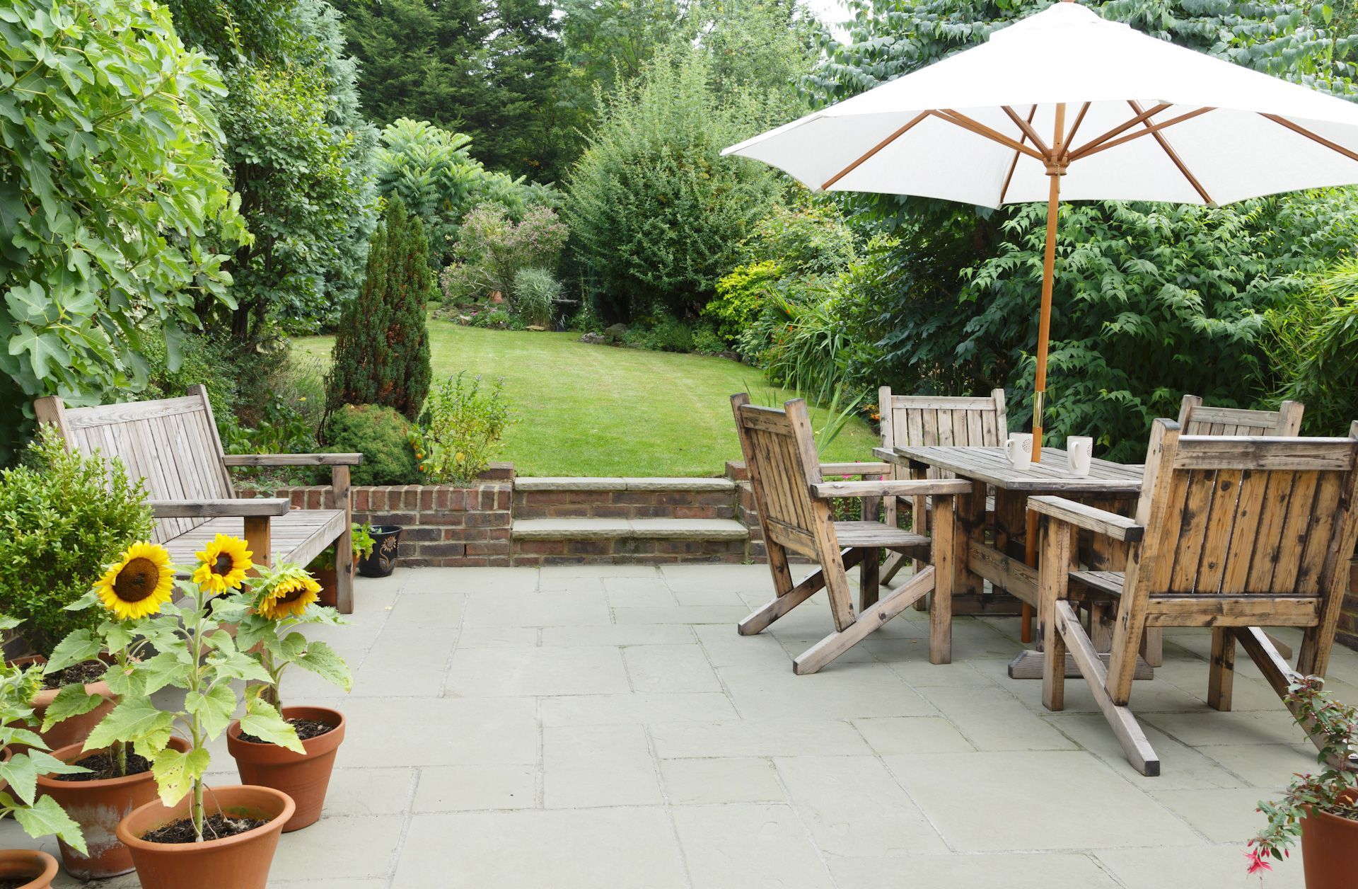 A patio with a table and chairs under an umbrella