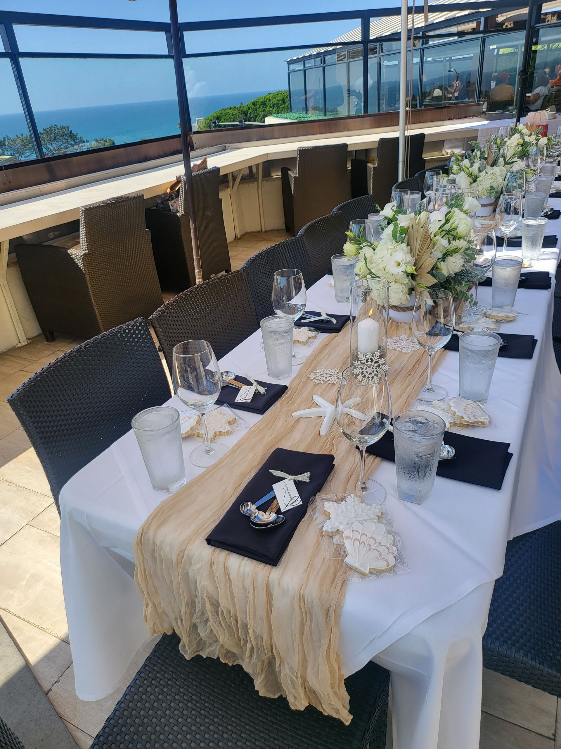 A long table with a table runner and flowers on it