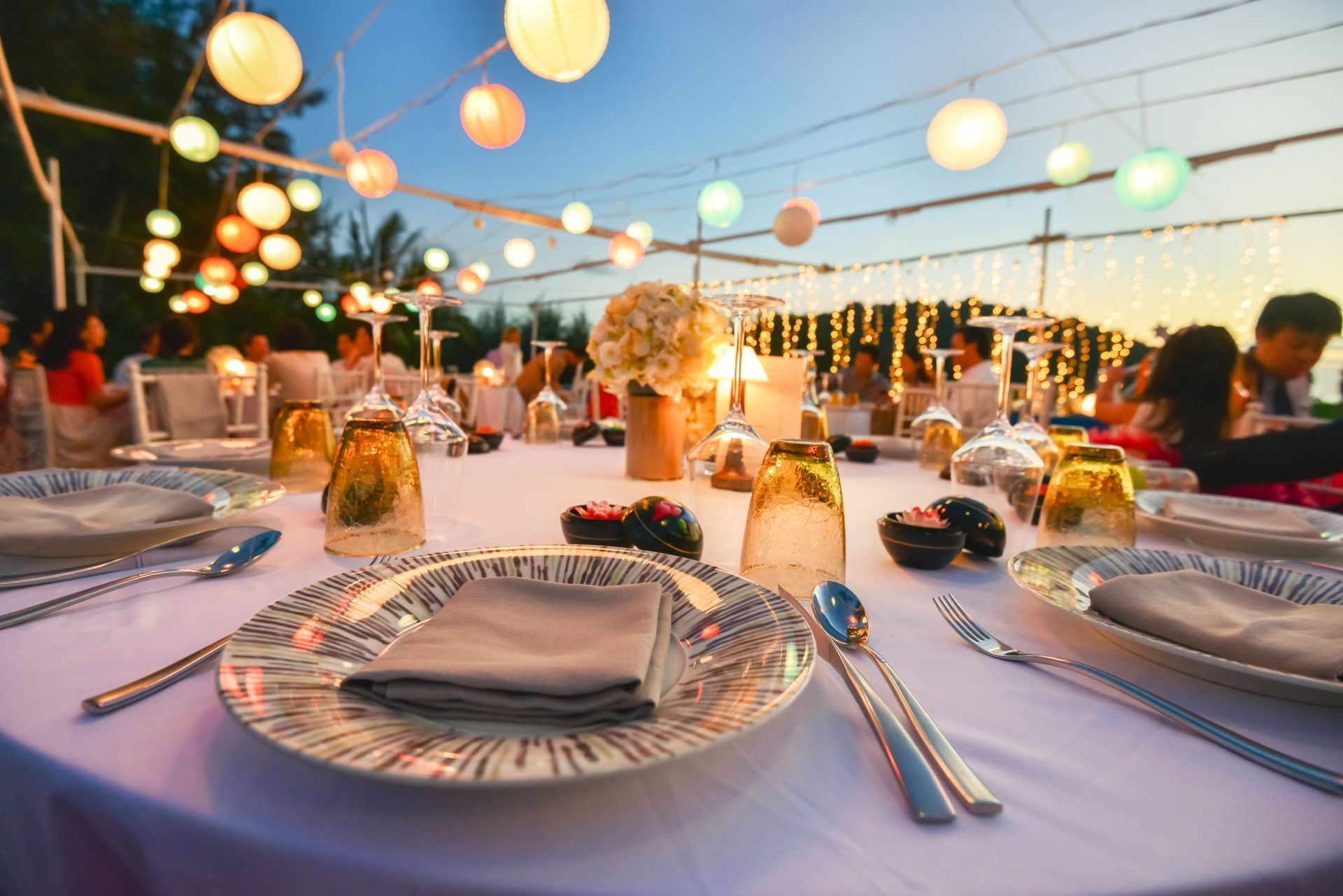A table set for a wedding reception with plates , glasses , and silverware.