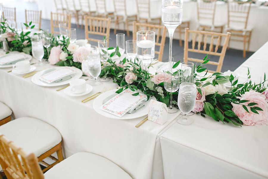 A vase filled with roses and daisies sits on a table
