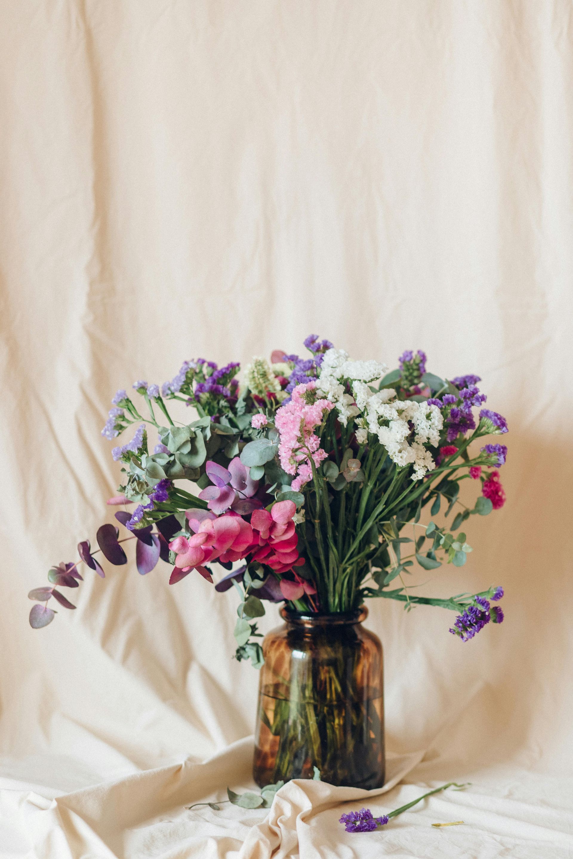 A bouquet of flowers in two vases on a table.