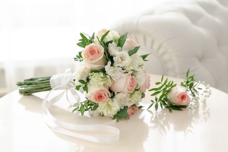 A bridal bouquet of pink and white flowers is sitting on a table.