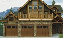 A large house with wooden garage doors and a balcony.