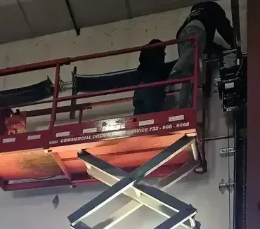 A man is working on a scissor lift in a building