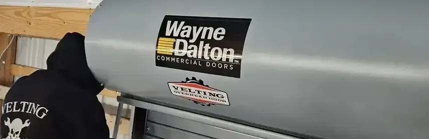 A man is standing in front of a wayne dalton grill.