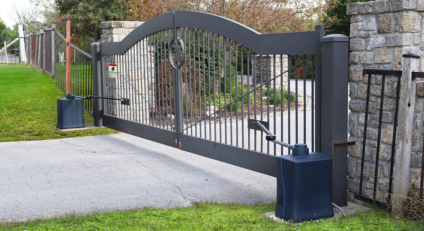 A black sliding gate is open to a driveway.