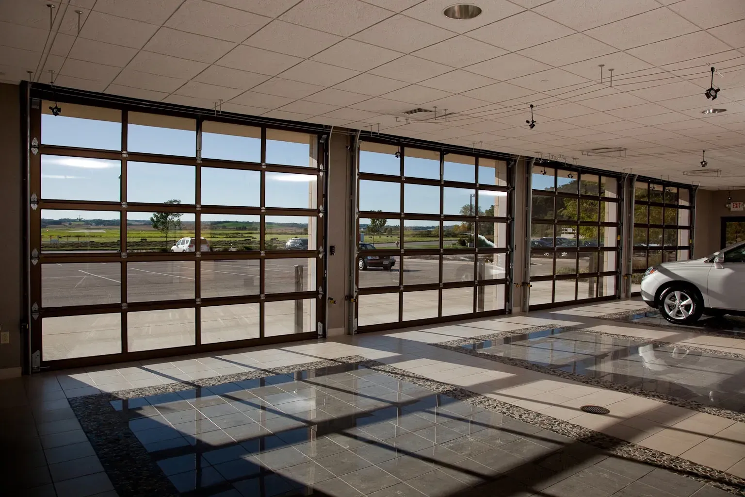 A car is parked in a garage with a lot of windows.