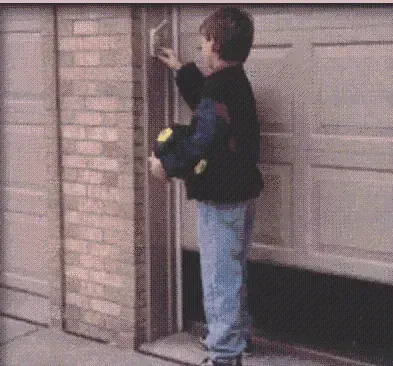 A boy is standing in front of a garage door