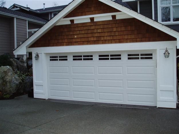 A white garage door with a wooden roof