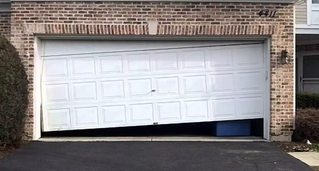 A white garage door is broken in half.