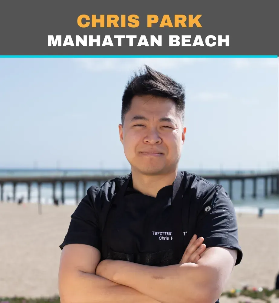 Chris Park standing on Manhattan Beach with arms crossed, wearing a black shirt, with a pier in the background
