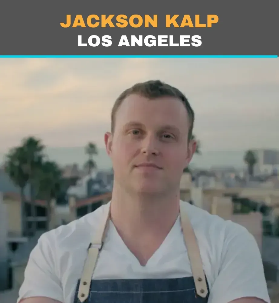 Portrait of Jackson Kalb in a white shirt and apron, standing outdoors with Los Angeles in the background
