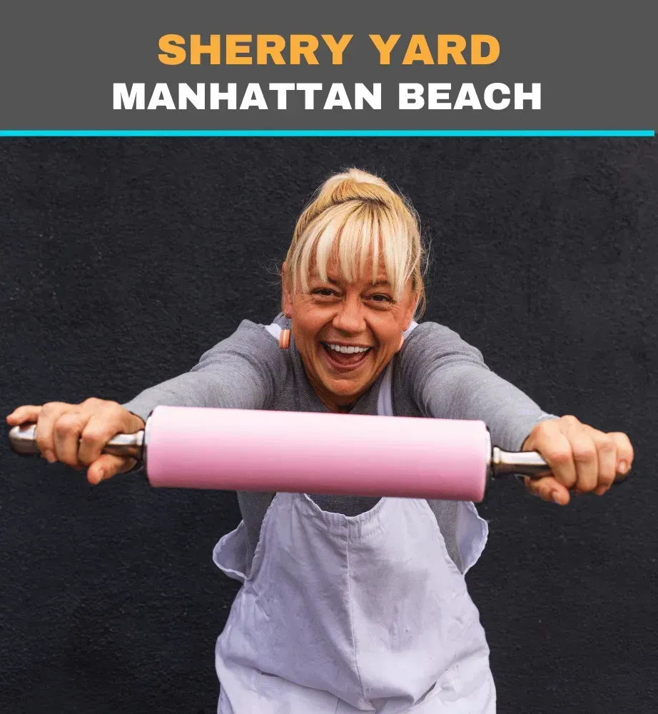 Sherry Yard at Manhattan Beach smiling while holding a pink rolling pin toward the camera