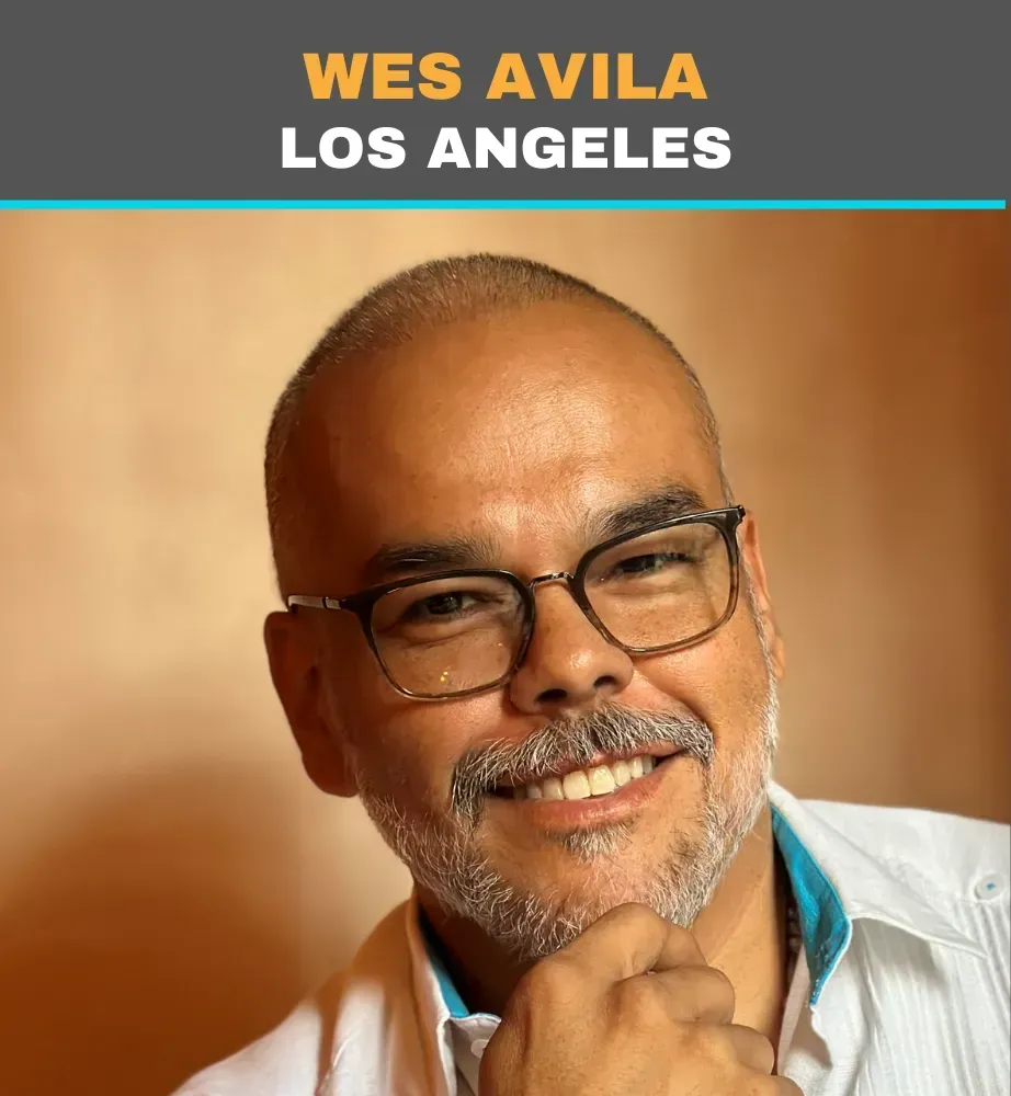 Portrait of Wes Avila in Los Angeles, smiling with glasses and a hand on his chin
