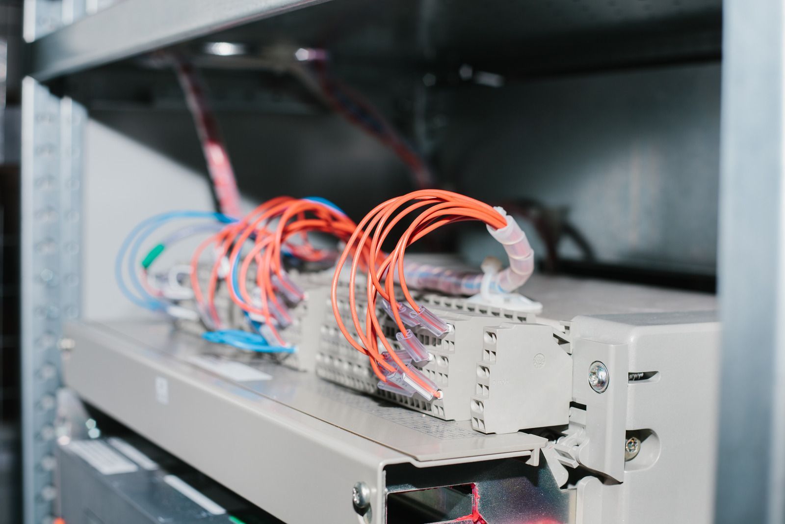 A bunch of wires are connected to a server in a server room.