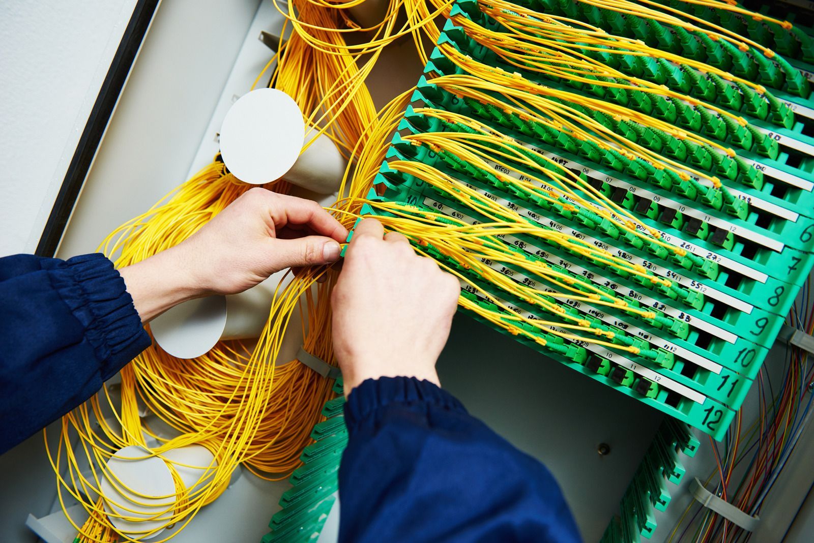 A person is working on a bunch of wires in a box
