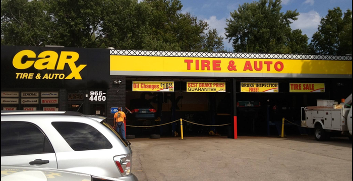 CarX Tire & Auto storefront with vehicles, a person, and yellow signage.
