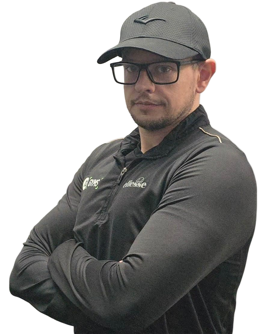 Man in black cap and shirt, arms crossed, wearing glasses, looking towards the viewer.