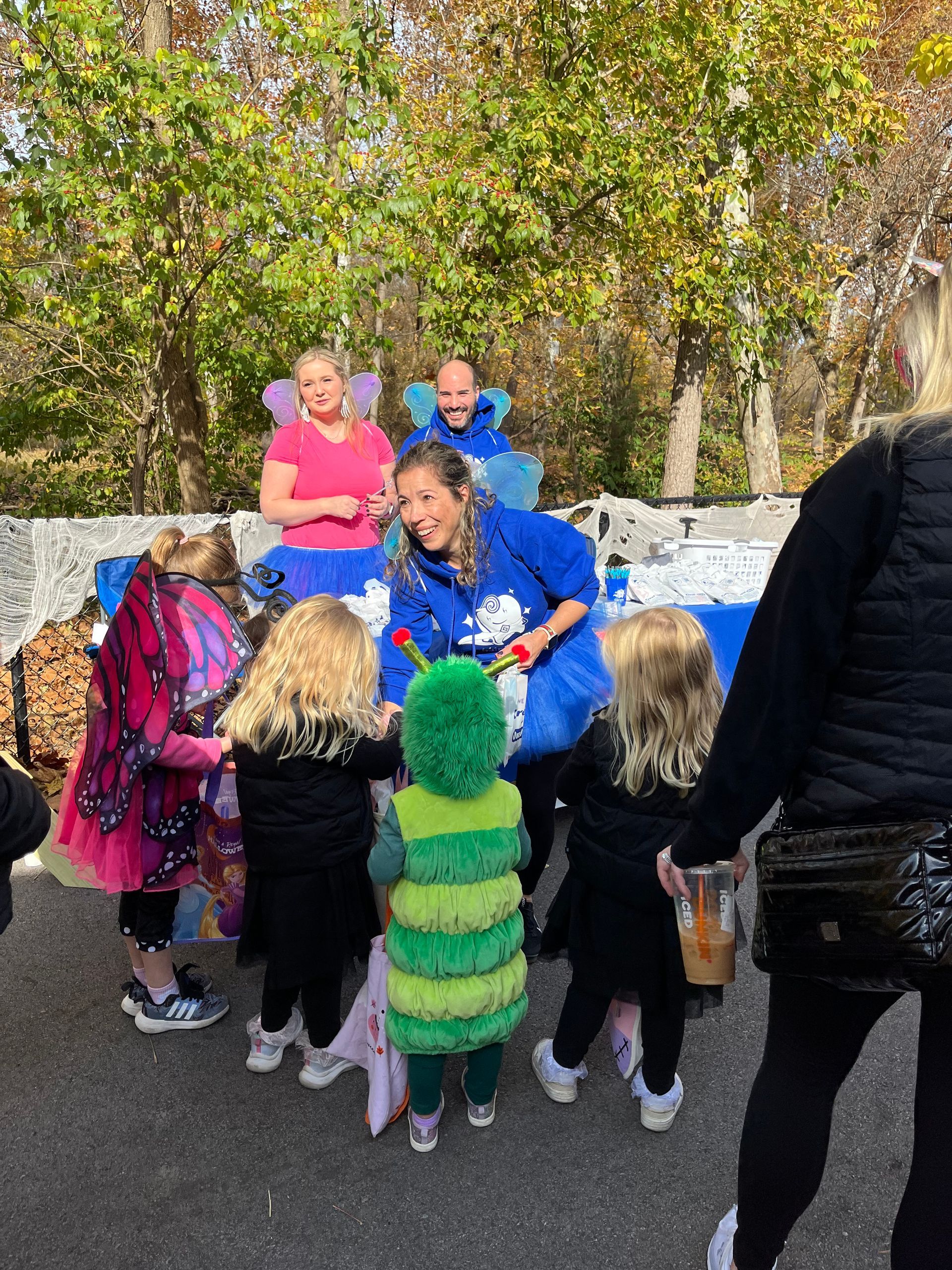 A group of children in costumes are standing around a table.