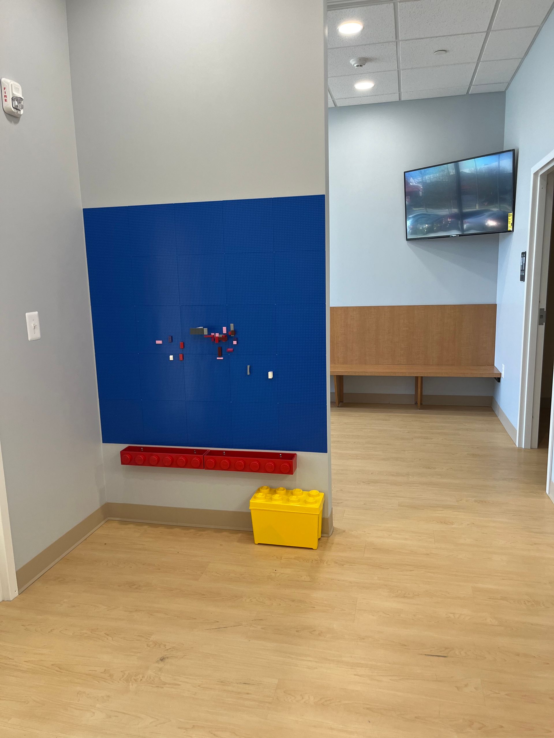 A room with a blue wall and a yellow box on the floor.
