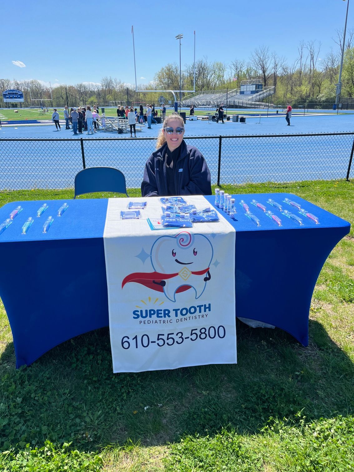 A woman is sitting at a table in front of a body of water.