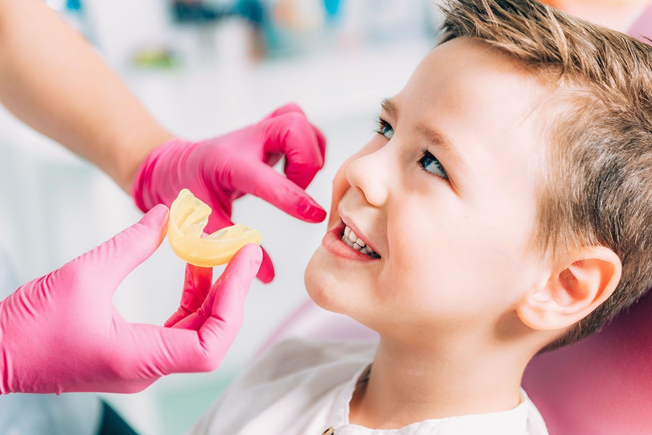 A young boy is getting his teeth examined by a dentist.