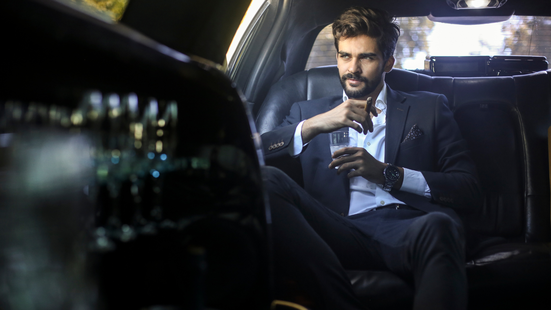 A group of women are sitting in a limousine toasting with champagne glasses.