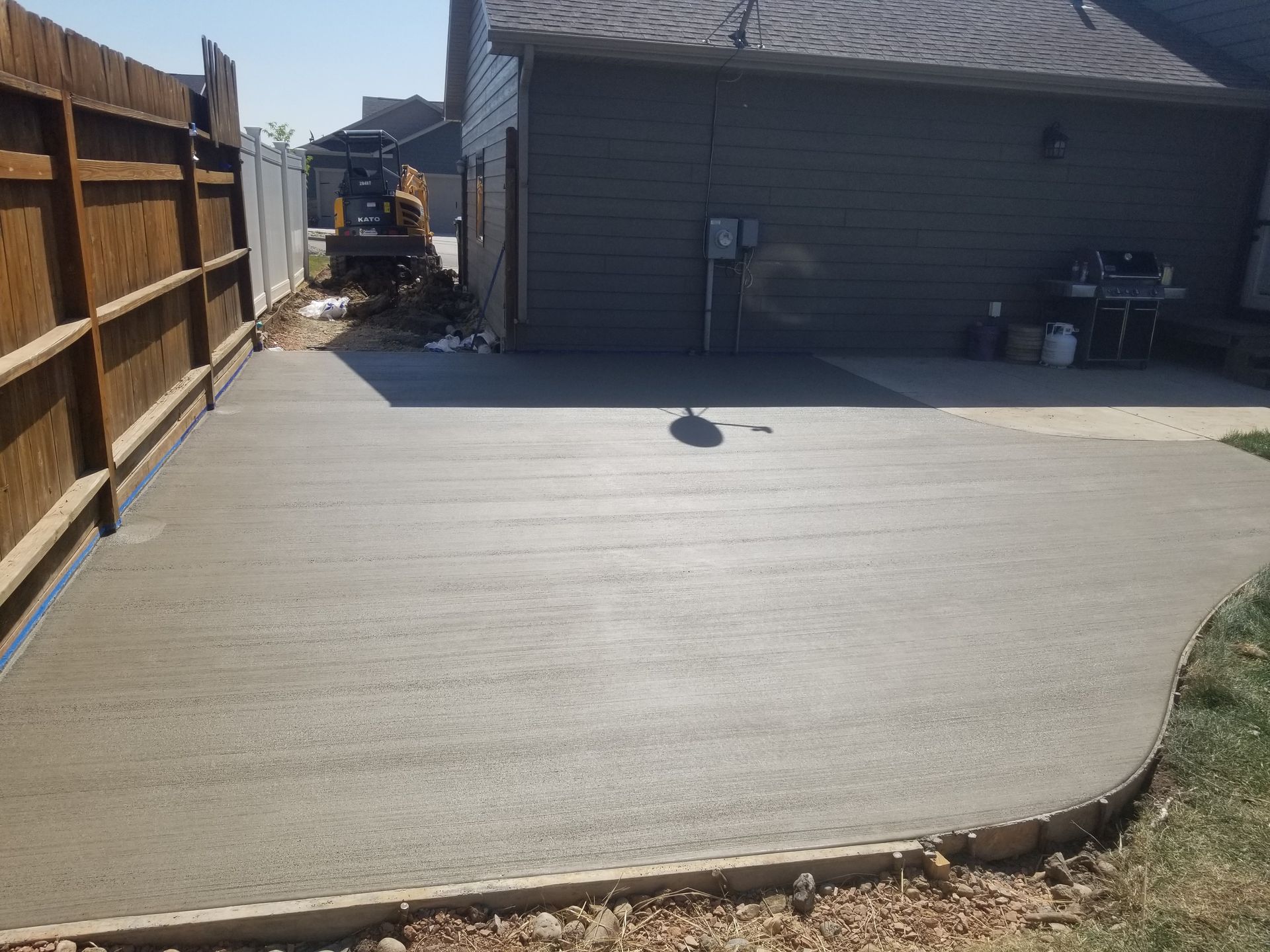 A concrete walkway is being built in front of a house.