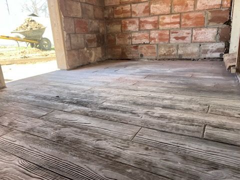 A man is sweeping the sidewalk in front of a house.