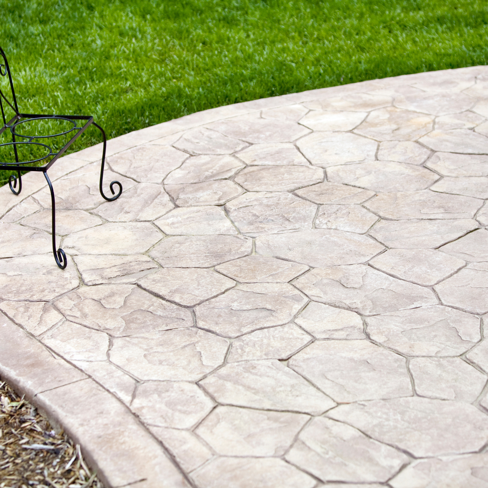 A man is working on a concrete patio in front of a house