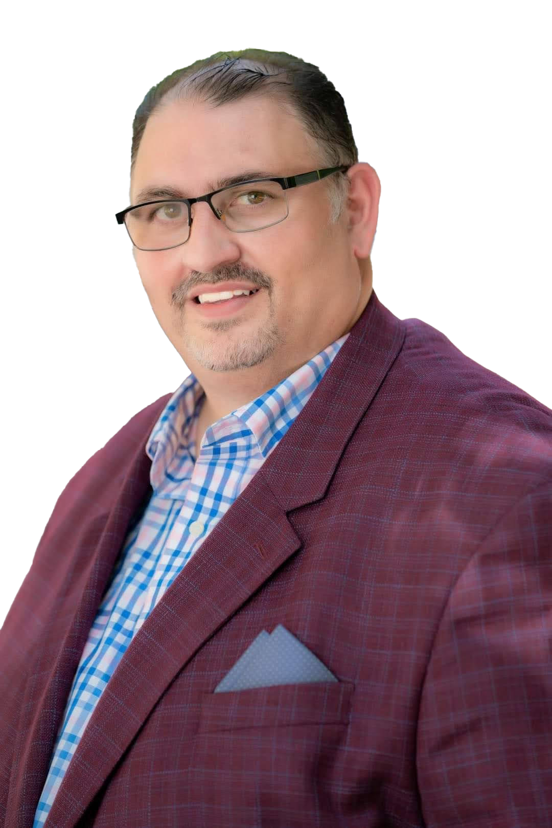 A woman is sitting at a desk with a laptop and a vase of flowers.