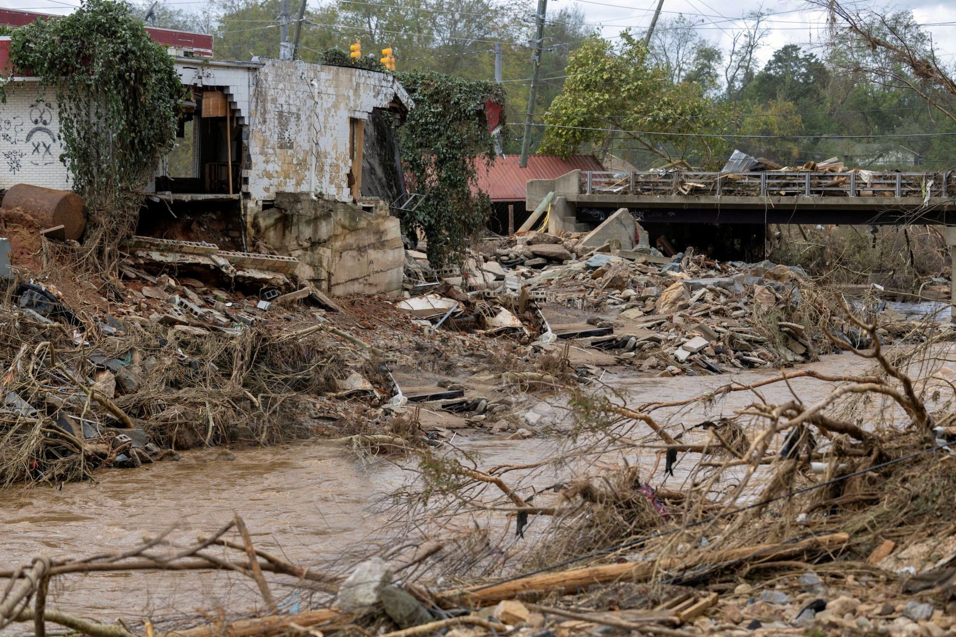 A flooded area with a bridge in the background and a building in the background.