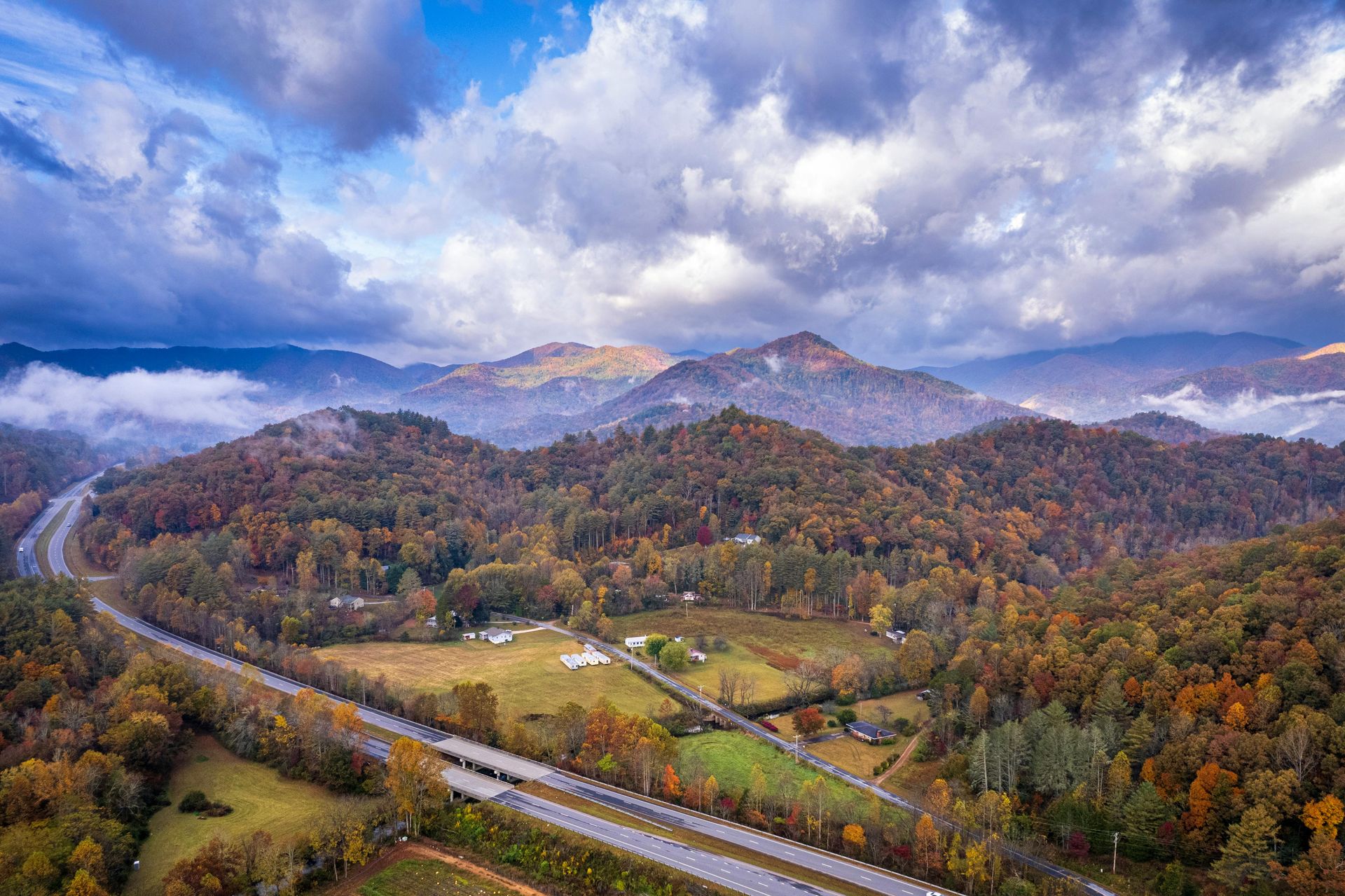 An aerial view of a highway going through a mountain range.