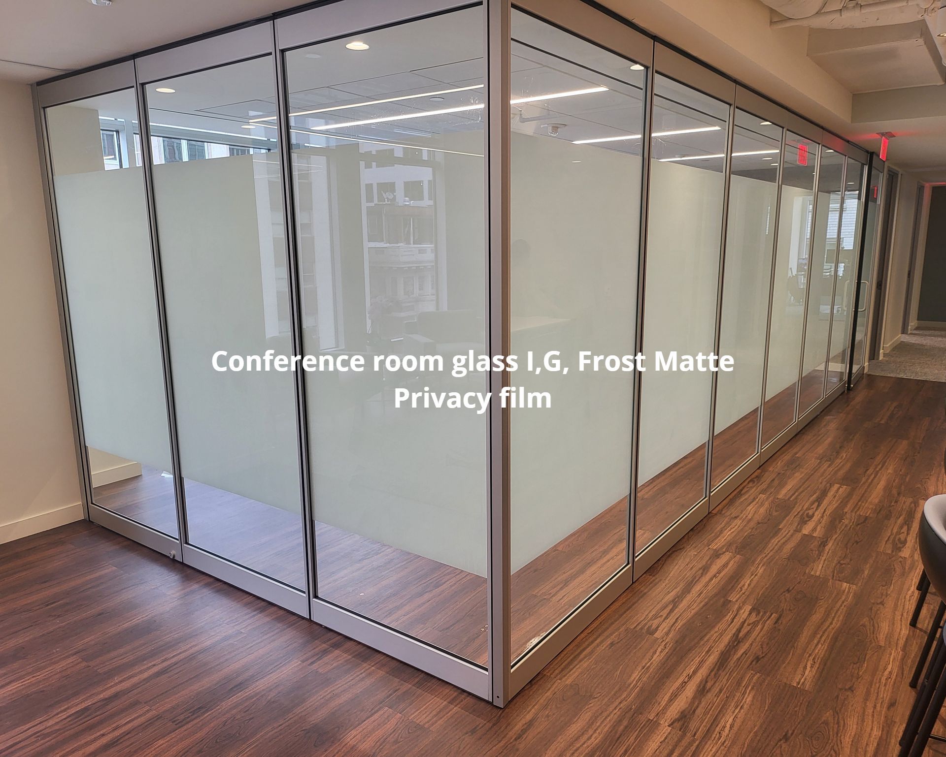 A room with a lot of glass walls and a wooden floor.